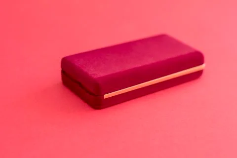 Rectangular red velvet box is closed for the chain on a red background Stock Photos