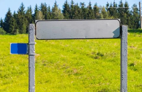 Rectangular road sign from the back side against a background of green grass  스톡 사진