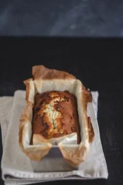 Rectangular ruddy metropolitan cake-bread in a metallic baking dish on a dark Foto stock
