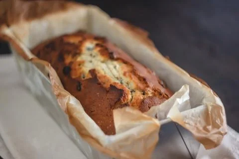 Rectangular ruddy metropolitan cake-bread in a metallic baking dish on a dark Foto stock
