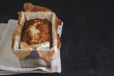 Rectangular ruddy metropolitan cake-bread in a metallic baking dish on a dark Foto stock