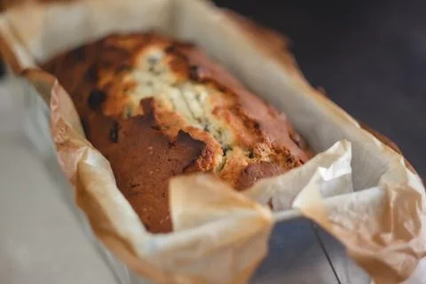 Rectangular ruddy metropolitan cake-bread in a metallic baking dish on a dark Foto stock