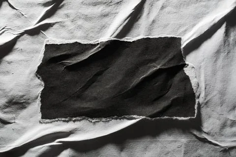 Rectangular scrap of black paper on a weathered white paper surface Stock Photos
