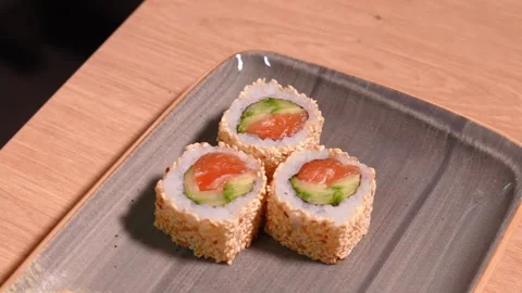 Rectangular sesame sushi dish with fish, rice, cucumbers, nori Stock Footage 269545923