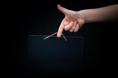 Rectangular shaped black notice board in hand on black background 스톡 사진