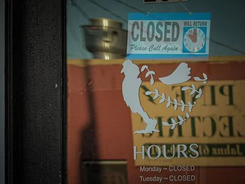 Rectangular-shaped closed sign and a rooster sticker in a window 스톡 사진