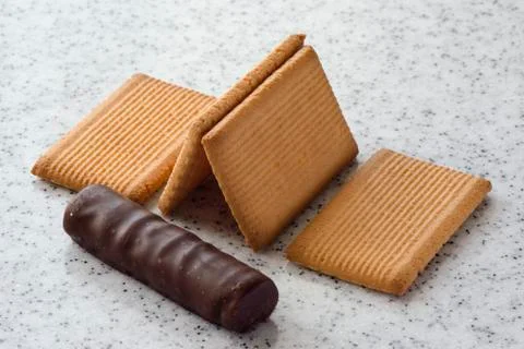 Rectangular shortbread cookies and chocolates on a light marble top. Stock Photos