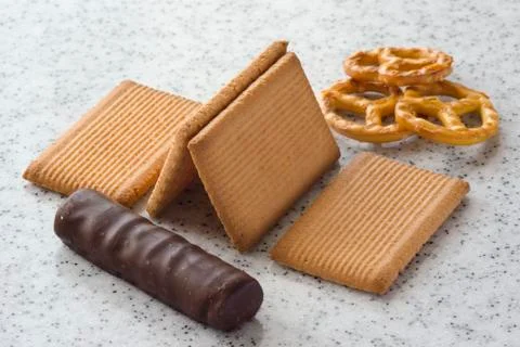 Rectangular shortbread cookies and chocolates on a light marble top. Stock Photos