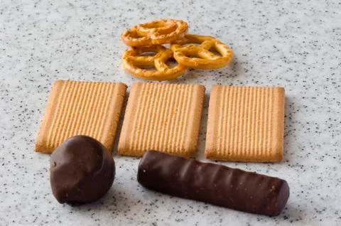 Rectangular shortbread cookies and chocolates on a light marble top. Stock Photos
