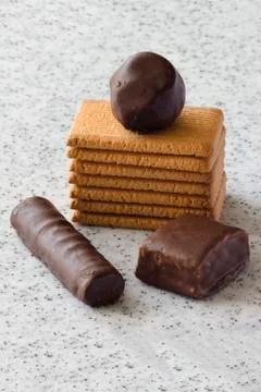 Rectangular shortbread cookies and chocolates on a light marble top. Stock Photos