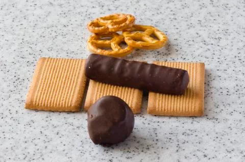 Rectangular shortbread cookies and chocolates on a light marble top. Stock Photos
