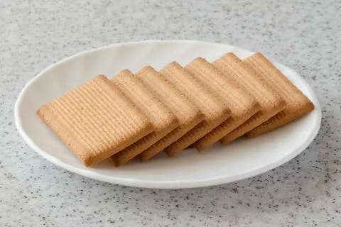 Rectangular shortbread cookies and chocolates in a white plate on a marble to Stock Photos