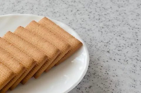 Rectangular shortbread cookies and chocolates in a white plate on a marble to Stock Photos