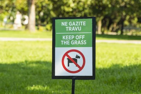 A rectangular sign prohibiting the walking of dogs and other animals on the lawn Stock Photos