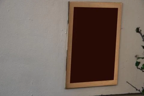 Rectangular sign on white wall. Frame is brass and center is brown Stock Photos