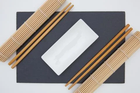 Rectangular slate plate with chopsticks, ceramic plate, bamboo mat for sushi  库存照片