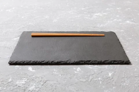 Rectangular slate plate with chopsticks for sushi on black marble background 库存照片