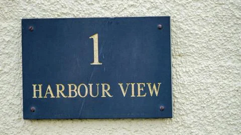 A rectangular slate tile with house name Harbour View near Tenby harbour Stock Photos
