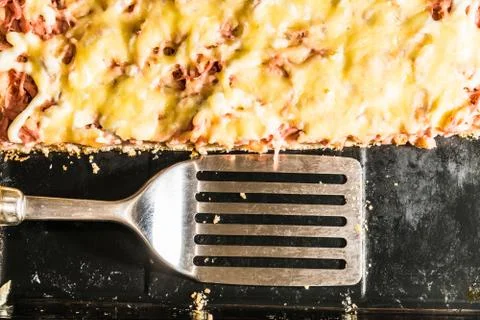 Rectangular slice of pizza on the shoulder, cooked at home, dish on a black t Stockfoto's