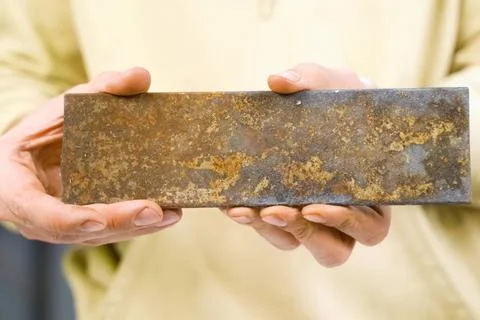 Rectangular steel piece in the hands of man. rusty iron. Foto stock