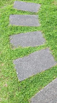 Rectangular Stone Pavers in Green Grass Lawn Stock-Fotos
