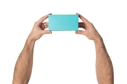 Rectangular turquoise box in male hands. Top view. White table on the backgro Foto stock