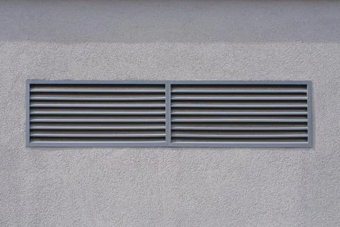Rectangular ventilation grille on a textured grey wall Stock Photos