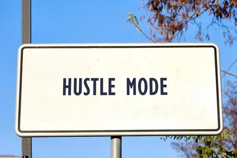 A rectangular white sign proclaims Hustle Mode in bold, dark lettering. The sign Stock Photos