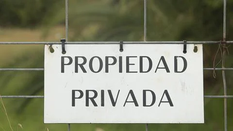 Rectangular white sign with the words "Private Property" written in Spanish Stock Photos