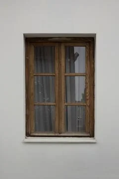 Rectangular window in a wooden brown frame on a light white wall 스톡 사진