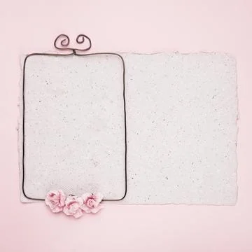 Rectangular wire frame decorated with roses paper against pink background 스톡 사진
