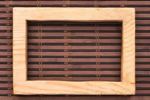 Rectangular wooden frame on a bamboo mat. Stock Photos