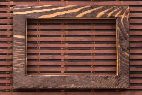 Rectangular wooden frame on a bamboo mat. Stock Photos