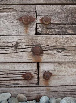 The rectangular wooden planks fastened with rusty large nails and pebbles on  스톡 사진