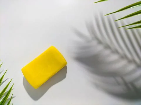 Rectangular yellow soap bar is placed on a white surface Stock Photos