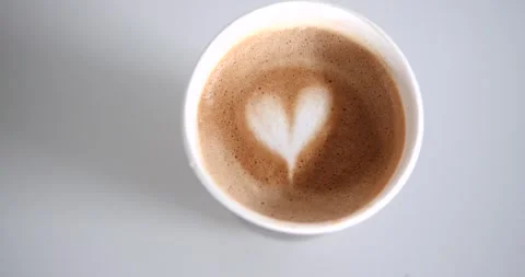 A recyclable eco cup in which hot cappuccino coffee with a heart pattern. Video stock 273711850