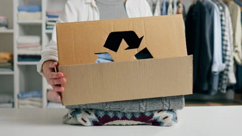 Recyclable materials, People sort and pack used clothes Caring person Select Video stock 243004040