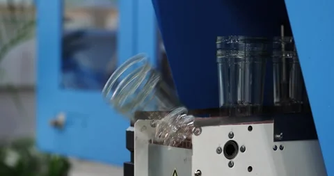 Recyclable plastic cups fall down from conveyor belt in manufacturing facility Stock Footage 341863992