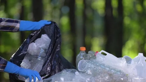 Recycle garbage to protect environment. Volunteer fighting pollution with Stock Footage 345543539