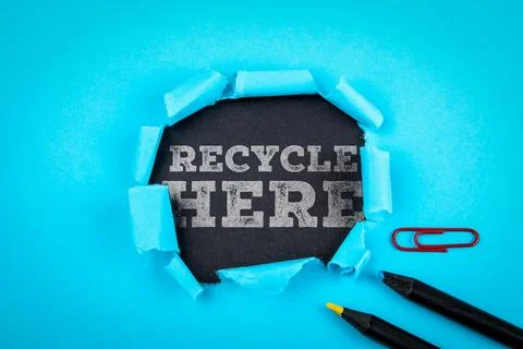 Recycle Here Text Revealed Through Torn Paper on Blue Background Stock Photos