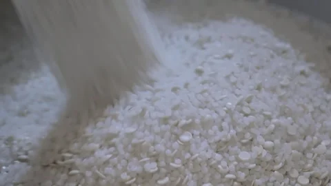 Recycled plastic granules, pellets falling into a large pile, heap - close up Stock Footage 344688543
