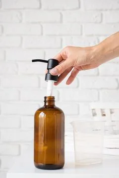 Recycled plastic pump bottle for mockup. woman putting dispenser into bottle Stock Photos