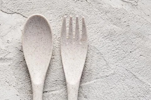 A recycled plastic spoon and fork on a rustic surface Stock Photos
