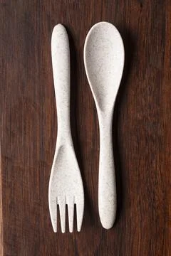 Recycled plastic spoon and fork on wood Foto stock
