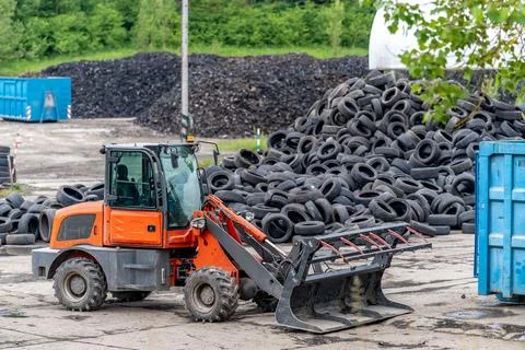 Recycling and processing of old tires, loader in stock of used tires Foto stock