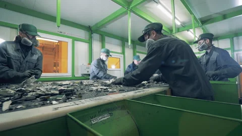 Recycling center workers sort trash on a conveyor. Stock Footage 136403359