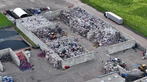 Recycling facility processes plastic waste at industrial site in operation Video stock 337983559