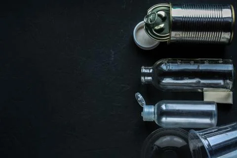Recycling garbage is scattered on a dark surface. Stock Photos
