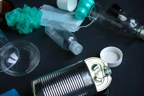 Recycling garbage is scattered on a dark surface. Stock Photos