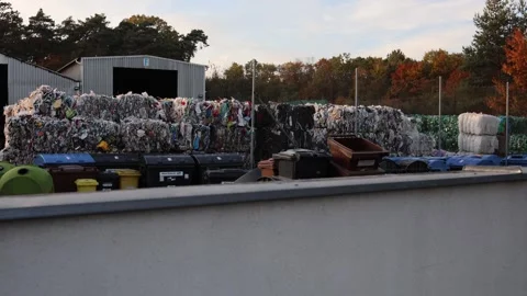 Recycling plant with stacks of compressed plastic waste and garbage bins near me Video stock 319833130